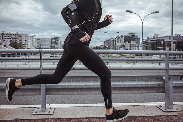 jungen fit mann laufen und musik hören - marathon sport sports training city street stock-fotos und bilder