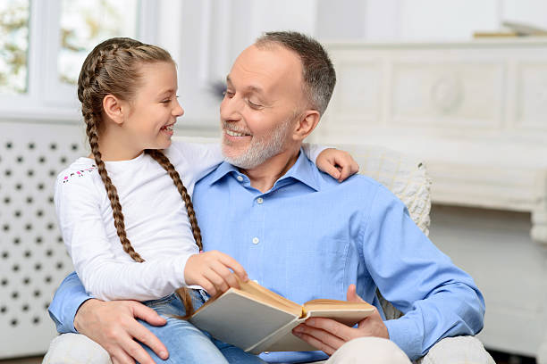 istock Grandfather with little girl reading book 493019152