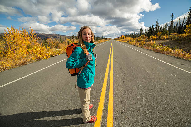 istock Lone woman standing on road ready to go 493023146