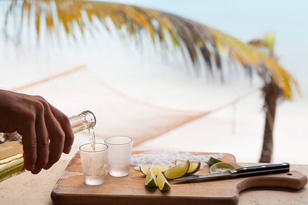 istock bartender's hand pouring tequila at a tropical Caribbean beach 493027330