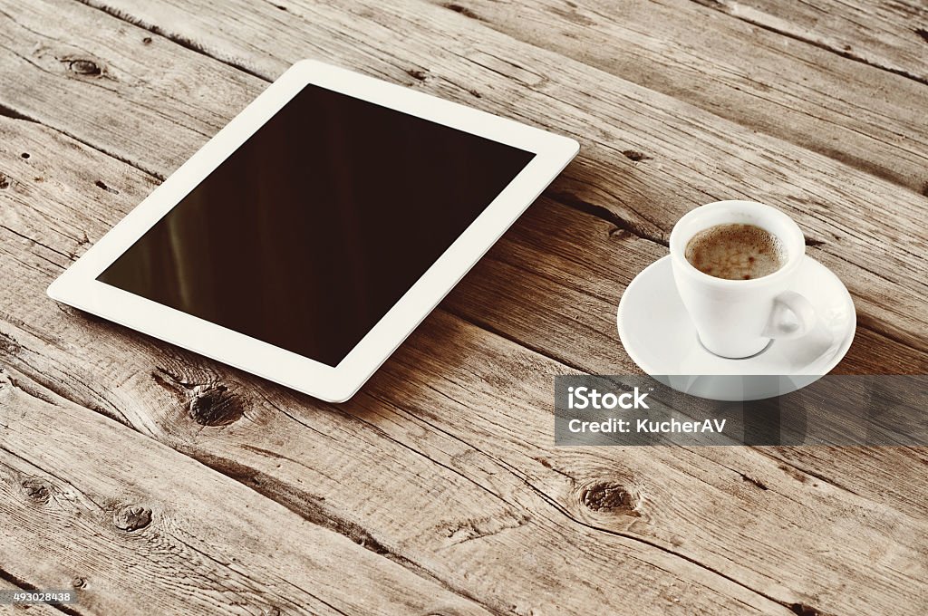 White tablet computer with cup coffe White tablet computer with cup coffe on a wooden table. Top view. Copy space. Free space for text. Office desk mock up. Vintage toning 2015 Stock Photo