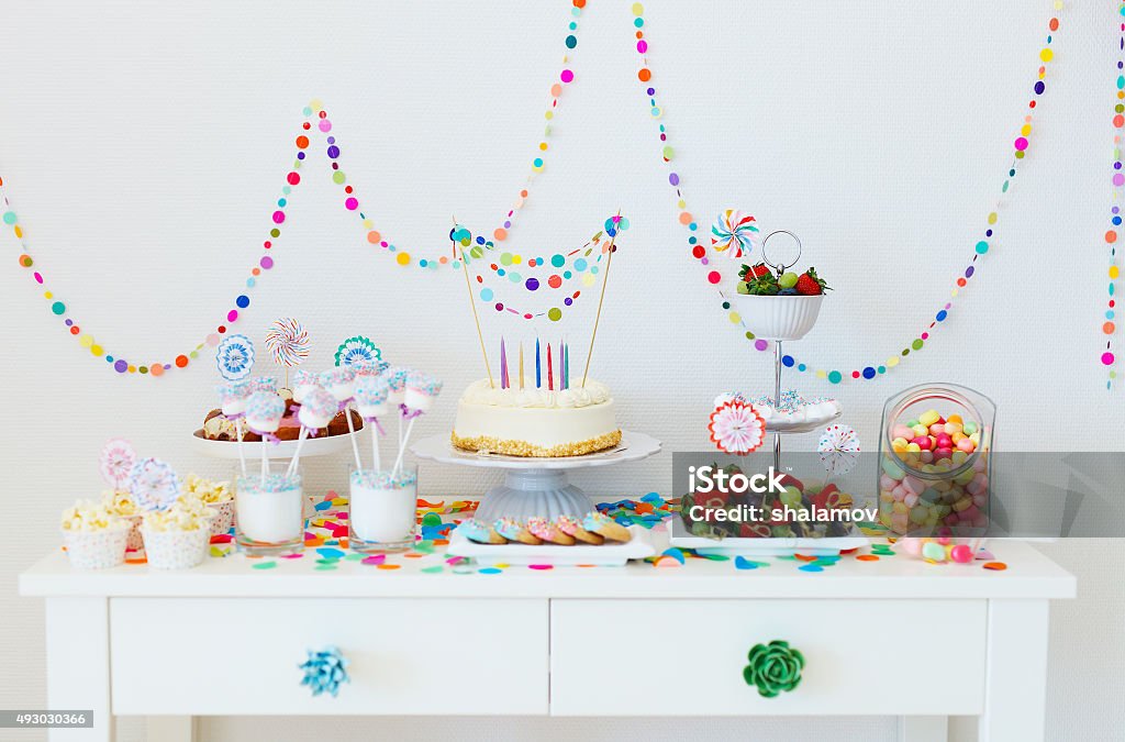 Dessert table at party Cake, candies, marshmallows, cakepops, fruits and other sweets on dessert table at kids birthday party Interior Decor Stock Photo
