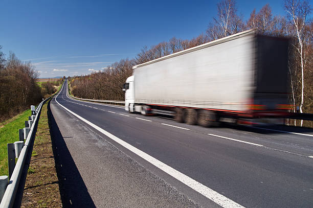 istock Speeding motion blur white truck on empty asphalt road 493031632