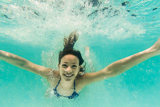 istock Smiling 8-Year-Old Girl Diving Underwater 493033310