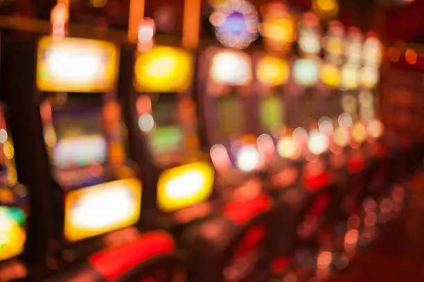 Defocused row of slot machines in casino. Blured background photo.