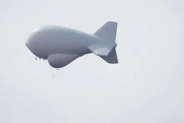 The Tethered Aerostat is an airborne and ground surveillance system which sits high above the Huachuca Mountains in a grey sky. It keeps watch over the Arizona/Mexico Border.