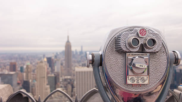 istock public telescope pointed on Manhattan buildings 493055758