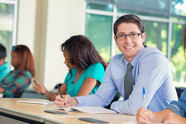 joven sonriendo a la cámara durante la universidad de - exam business caucasian board room fotografías e imágenes de stock