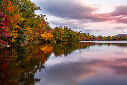 Fall foliage reflects in Hessian Lake at sunset, near Bear Mountain, NY
