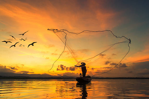 pescatore pesca al lago di mattina, tailandia. - fishing net foto e immagini stock