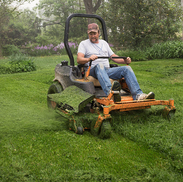 istock Man cutting grass on a riding lawnmower 493062526