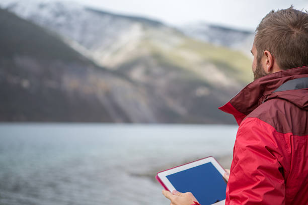 istock Man traveling photographing landscape using digital tablet 493066094