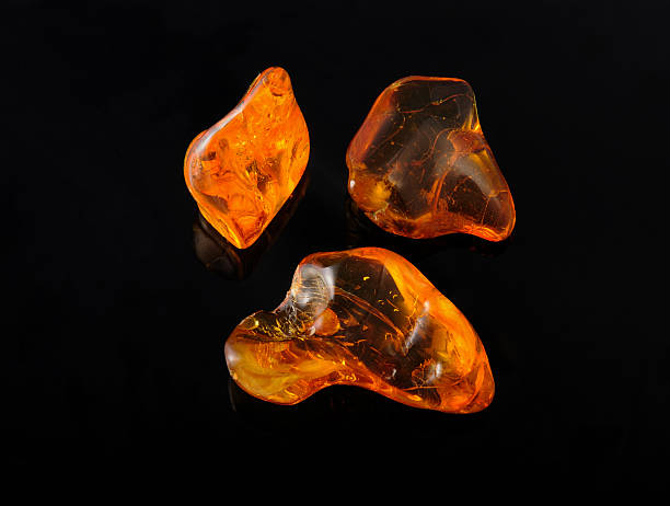 istock amber gemstone on black. Soft focus, photo toned 493067230