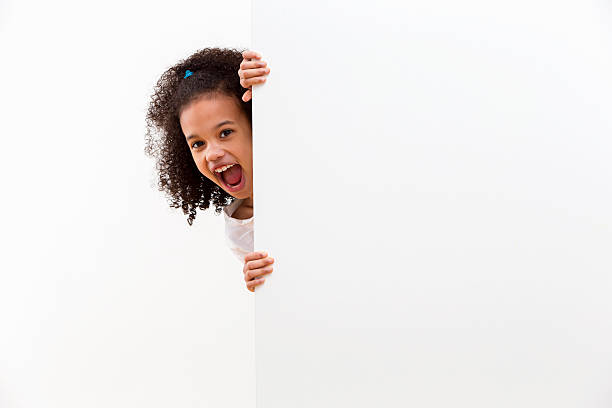 Girl With Cheeky Face Looking Around White Wall In Studio