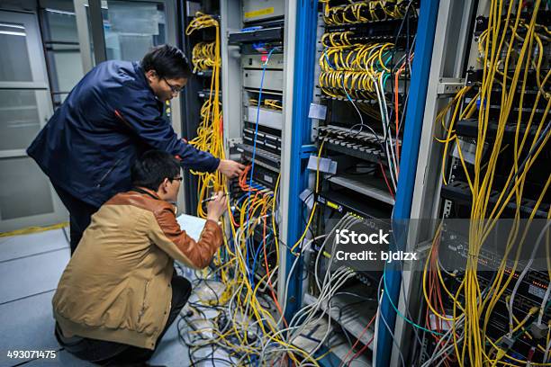 Foto de Dois Administradores De Rede Estão Trabalhando Na Sala Do Servidor e mais fotos de stock de Administrador