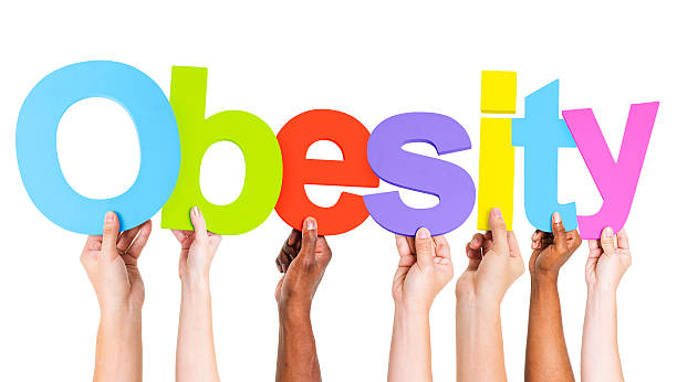 istock Multiethnic Arms Raised Holding Text Obesity 493071625