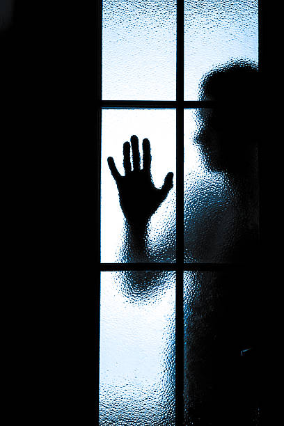 istock Scared boy behind glass door 493074197