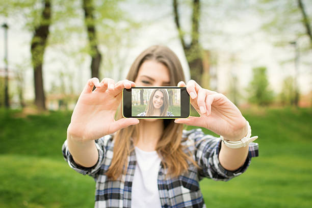 Linda chica adolescente tomando un autorretrato fotografía con teléfono inteligente - foto de stock