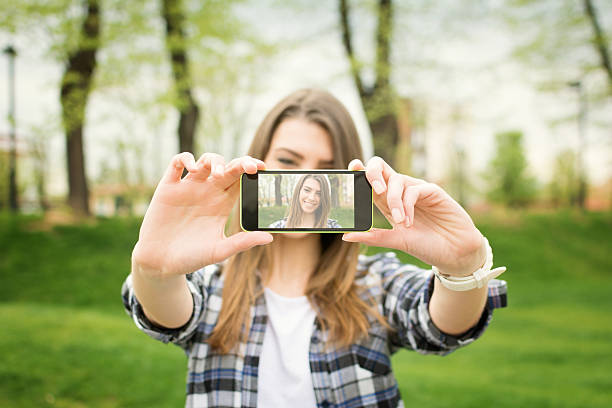 Carina Ragazza adolescente prendendo una foto selfie con telefono intelligente - foto stock