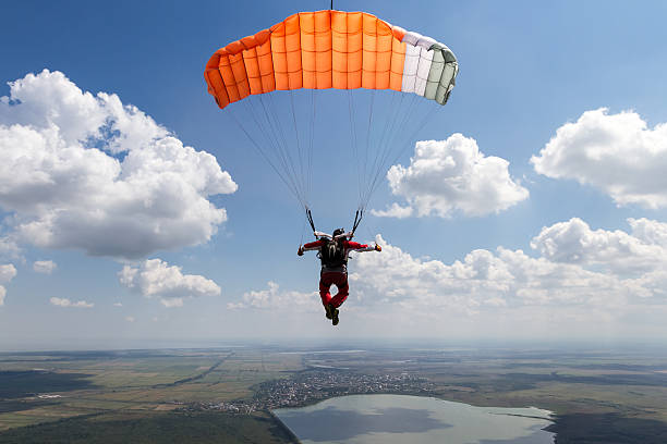 Skydiving photo. Piloting the parachute in the clouds. parachuting stock pictures, royalty-free photos & images