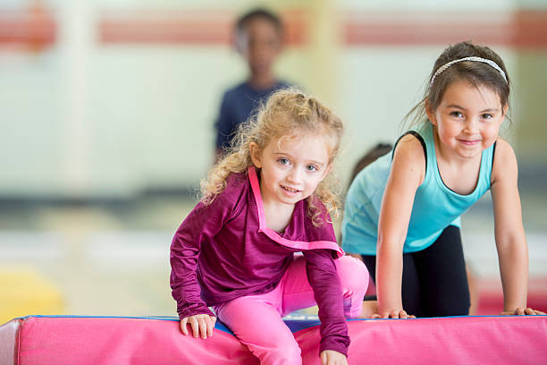 istock Little Girls Crawling Over Gym Mats 493082706
