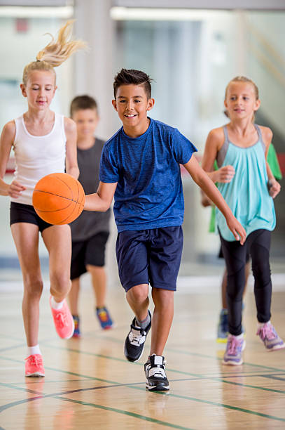 crianças jogar basquete no ginásio - child basketball sport education imagens e fotografias de stock