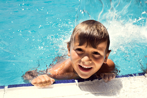 happy little boy swimming in the pool