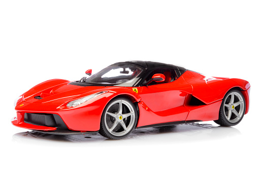 Kampen, The Netherlands - October 18, 2015: Red Ferrari LaFerrari hybrid sports car model car by Bburago isolated on a white background with a reflection in the foreground. The Ferrari LaFerrari, also known as Ferrari F150 is a hybrid supercar with a V12 engine and a KERS unit for extra power.
