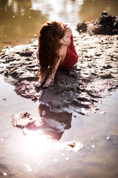 istock Redhead woman with obscured face in a mud. 493105738