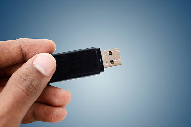 istock man hand holding up a flash drive 493106296