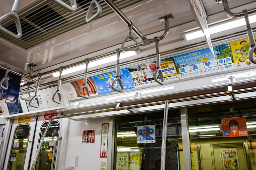 Tokyo, Japan - October 3, 2015: A detail of a train carriage on the Tokyo underground system. Lots of signs/advertising.