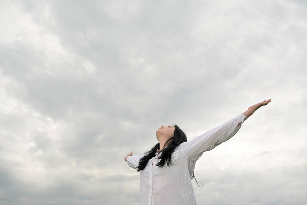 istock Young woman and clouds, arms stretched out 493111948