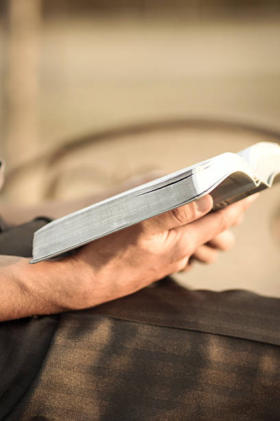 istock young man reading the Bible on a park bench 493113990