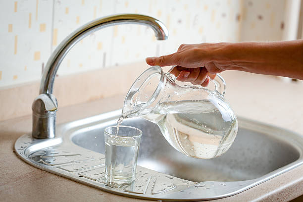 istock Hand pouring water into glass 493118322