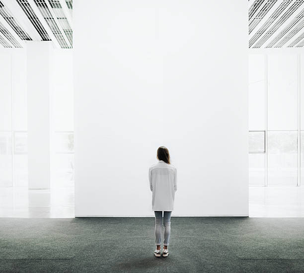 istock Young woman walking through a gallery and looking at the 493149912