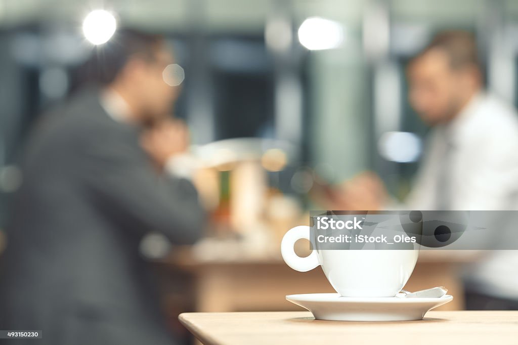 Cup of coffee on a table Cup of coffee on a table with a business partners in the background Coffee - Drink Stock Photo