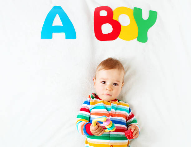 istock Baby boy lying on the blanket with letters above 493150716
