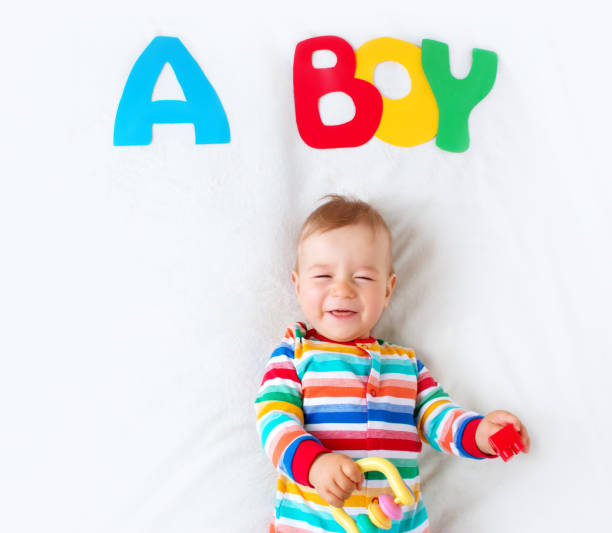 istock Baby boy lying on the blanket with letters above 493150810