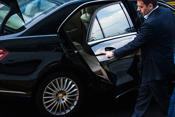 luxury service London. UK - May 20, 2015: Ðriver with assistant met the businessman at the airport in London. luxury Mercedes sedan. rainy day celebrity limo stock pictures, royalty-free photos & images