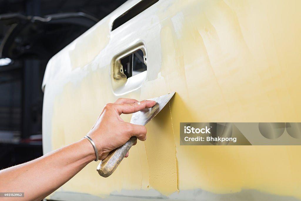 Car paint repair series : Working on putty Blue-collar Worker Stock Photo