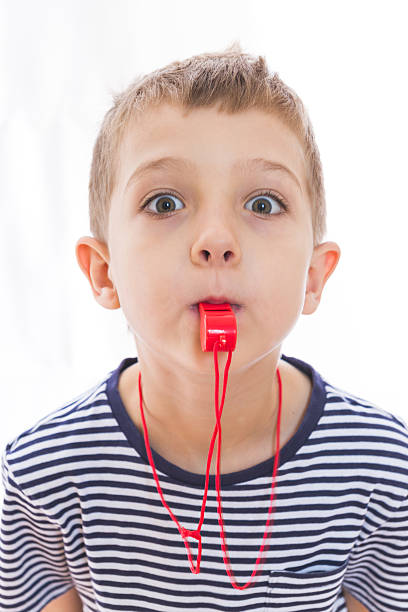 Young boy with a whistle in his mouth. stock photo