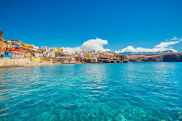 Cristall clear water and unspoiled canarian landscape at the beautiful fishing village of Sardina del Norte with its colorful houses. 
