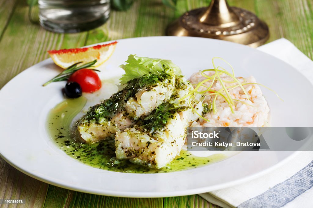 white fish with pesto sauce and meat plate in a white fish with pesto sauce and meat on a plate in a still life gourmet restaurant menu Pesto Sauce Stock Photo