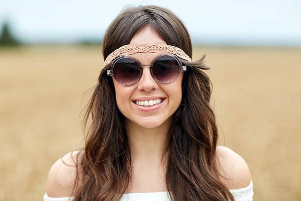 Outdoor portrait of the smiling cute young boho (hippie) girl in