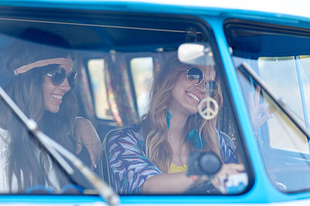 istock smiling young hippie women driving minivan car 493160460