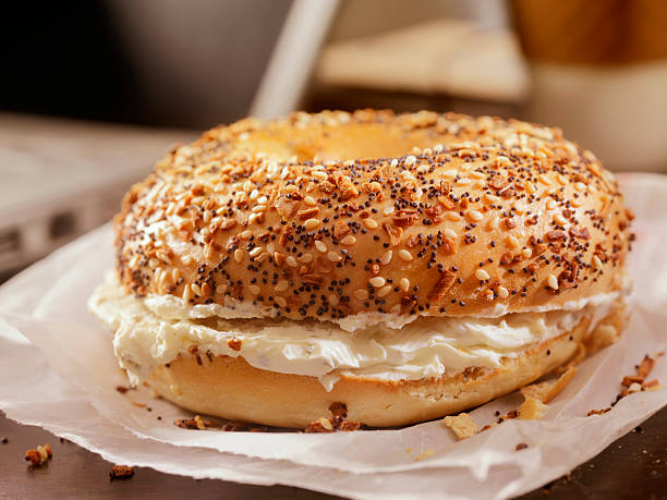 tostados pãozinho com creme de queijo na sua secretária - cream cheese imagens e fotografias de stock