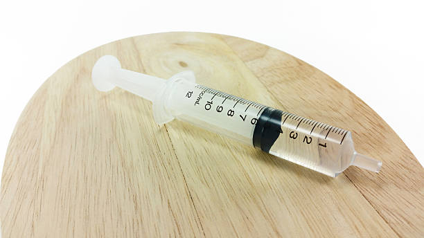 istock syringe on wood plate 493162272