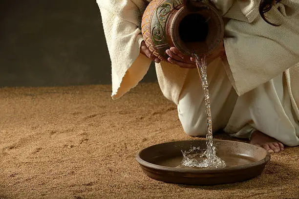 Jesus pouring water from a jug (with copyspace for text)