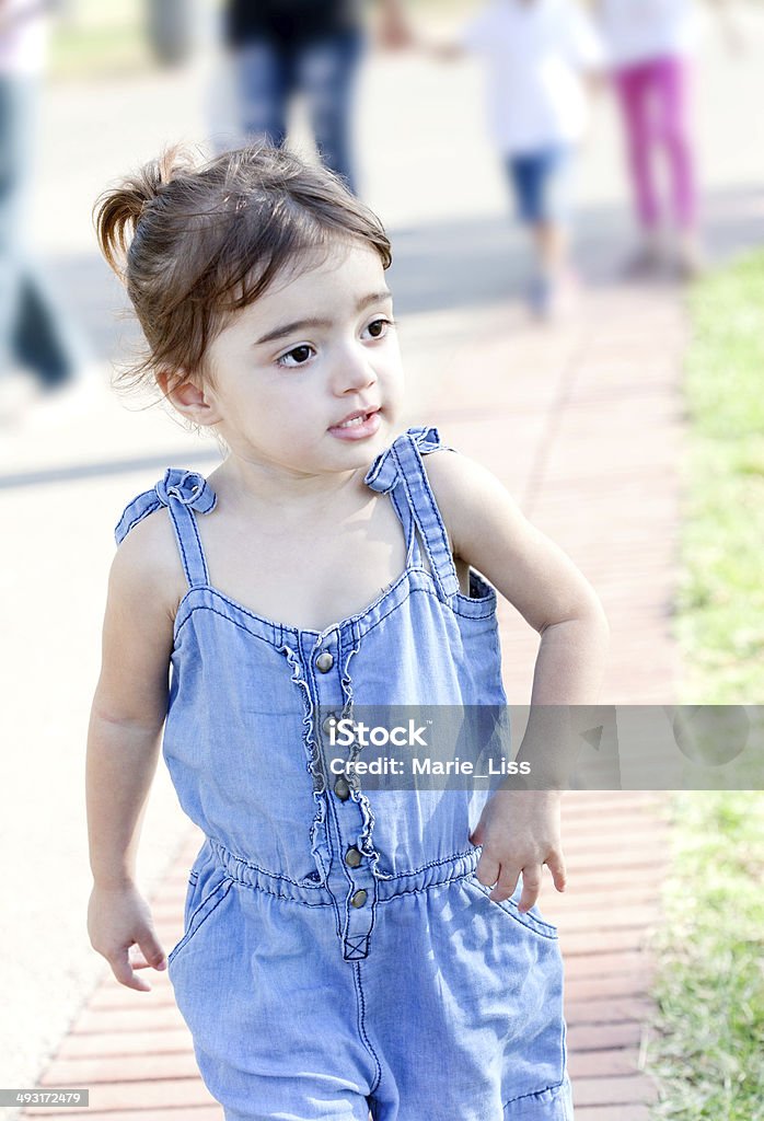 Cute toddler on a walk Cute toddler girl studying her suuroundings during a walk in a park 12-17 Months Stock Photo