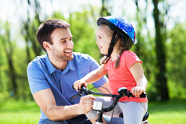 istock Girl learning to ride a bicycle with father 493173787